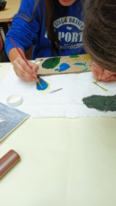 A concentração e dedicação  das alunas na pintura das espécies no tecido.
