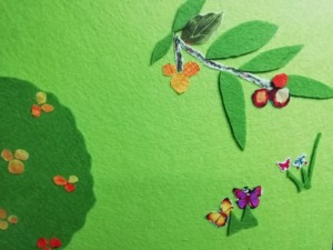 A foto representa um promenor do painel, mostrando um ramo de medronheiro com medronhos.